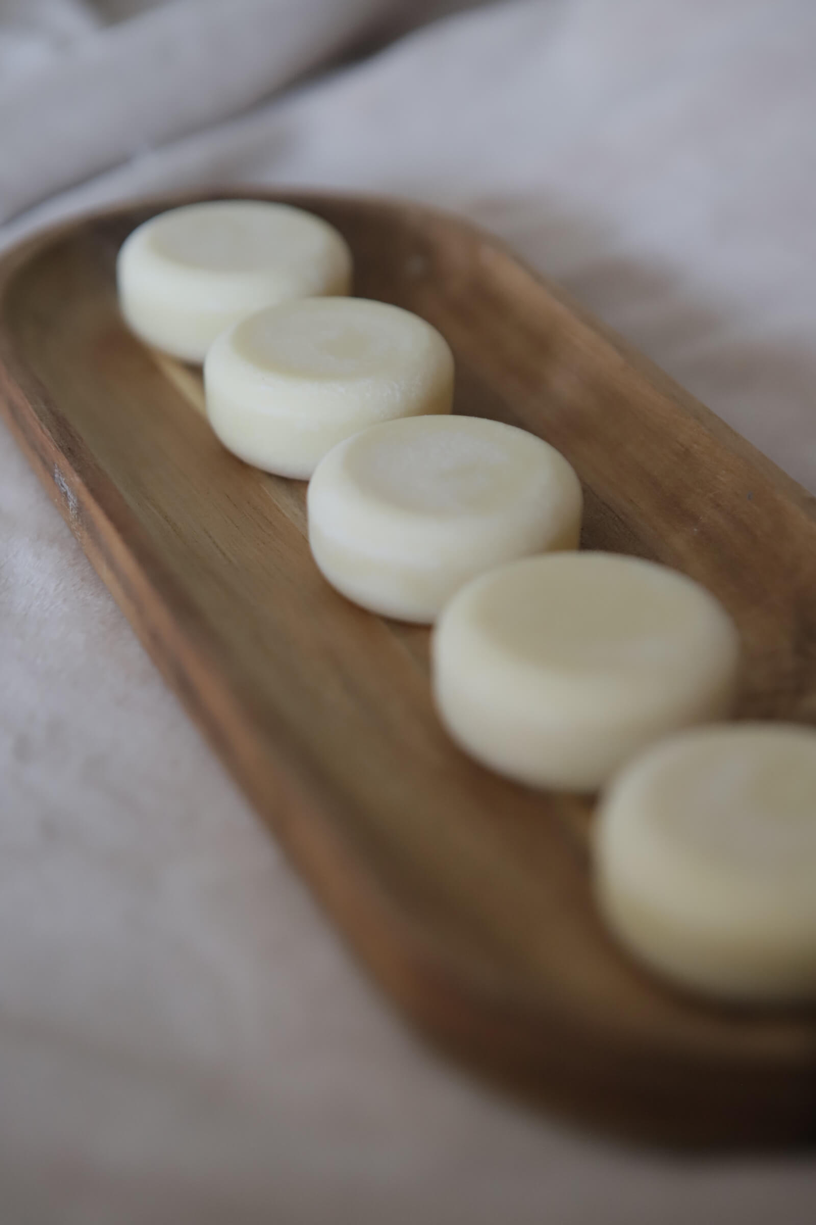White nude lotion bars on wooden tray
