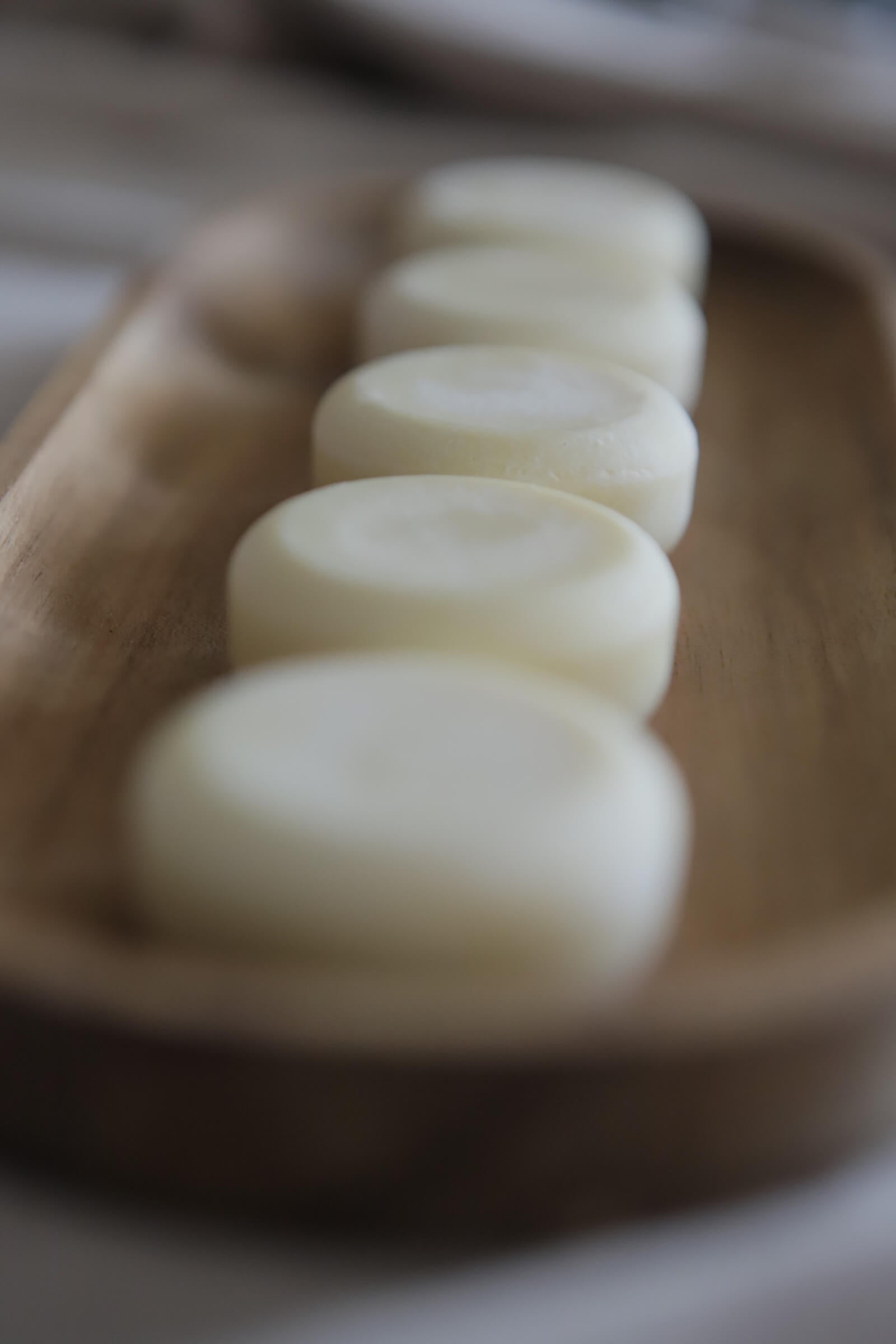 White nude circle lotion bars on wooden tray