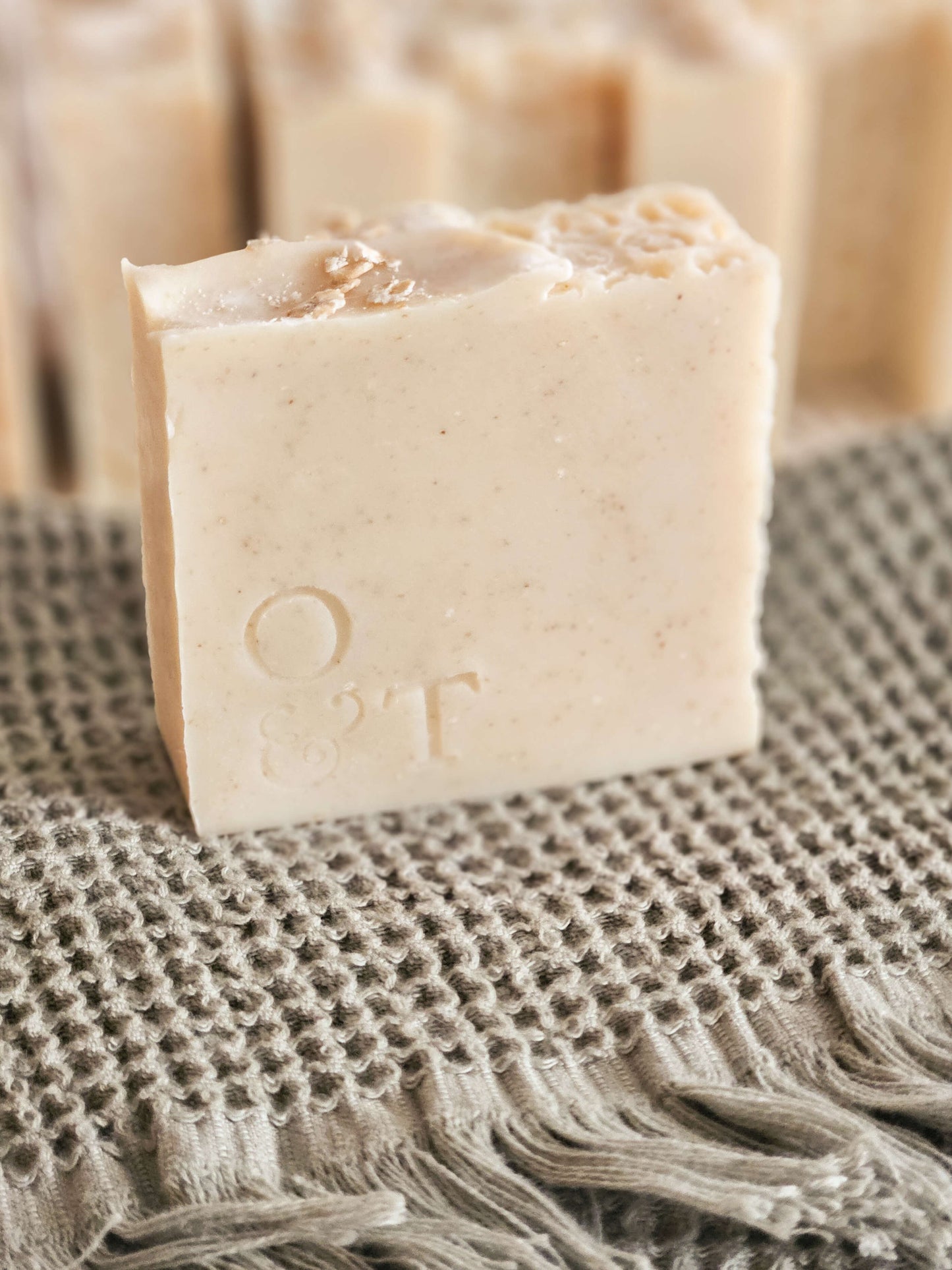 Nude soap bar standing and stamped with o&t logo