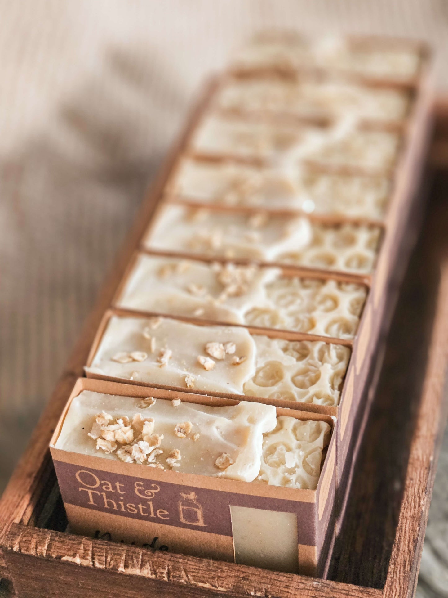 nude unscented uncoloured soap bar in packaging all stacked up with oats on top and honeycomb design