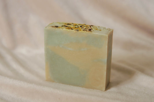 Mentha soap bar, soft yellow and green swirls, topped with calendula petals and nettle powder and stamped with the o&t logo