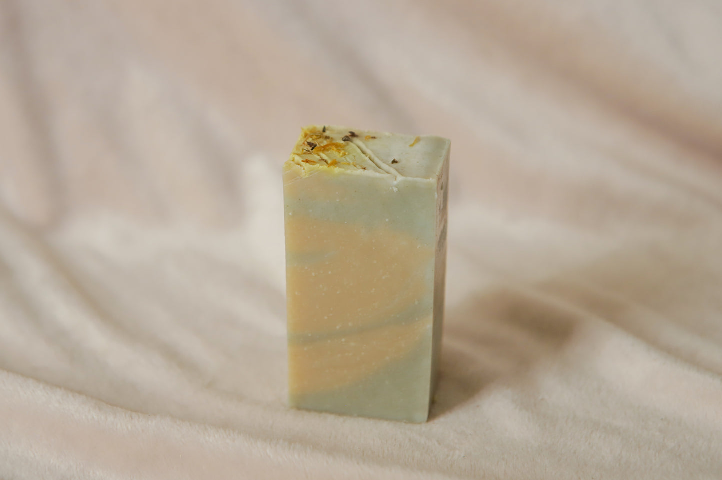 Mentha half soap bar, light yellow and green swirls topped with calendula petals and nettle powder
