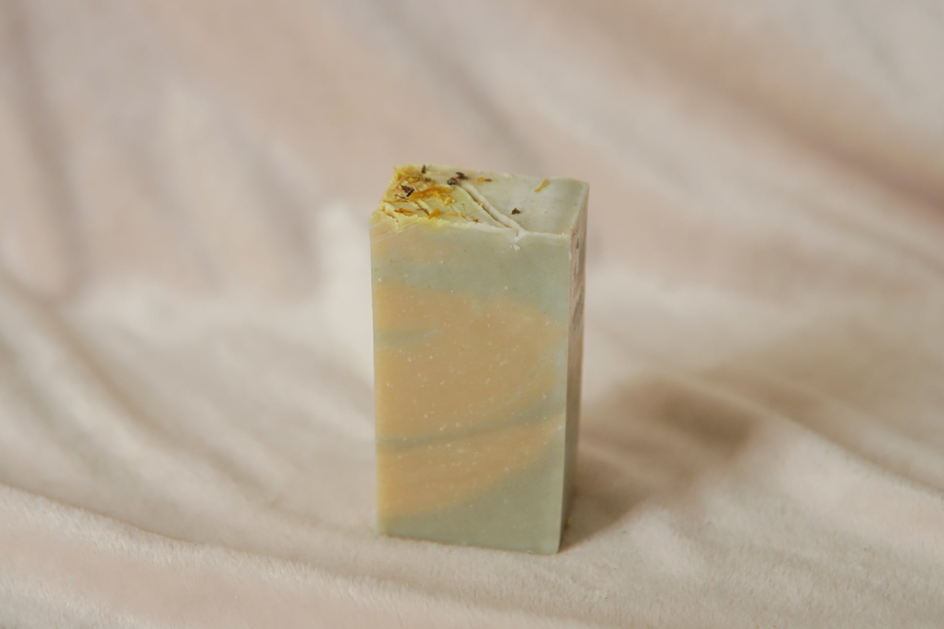 Mentha half soap bar, light yellow and green swirls topped with calendula petals and nettle powder