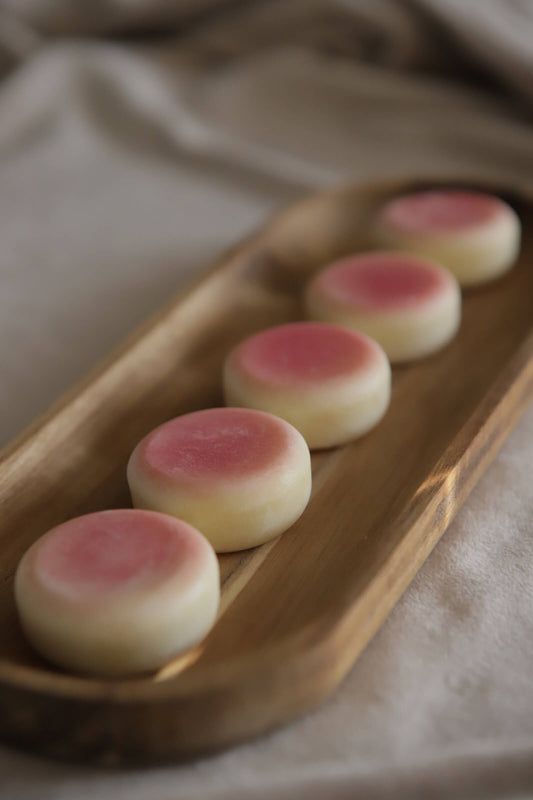 pink sol lotion bars on wooden tray