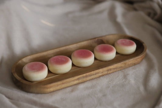 Pink sol lotion bars on a wooden tray