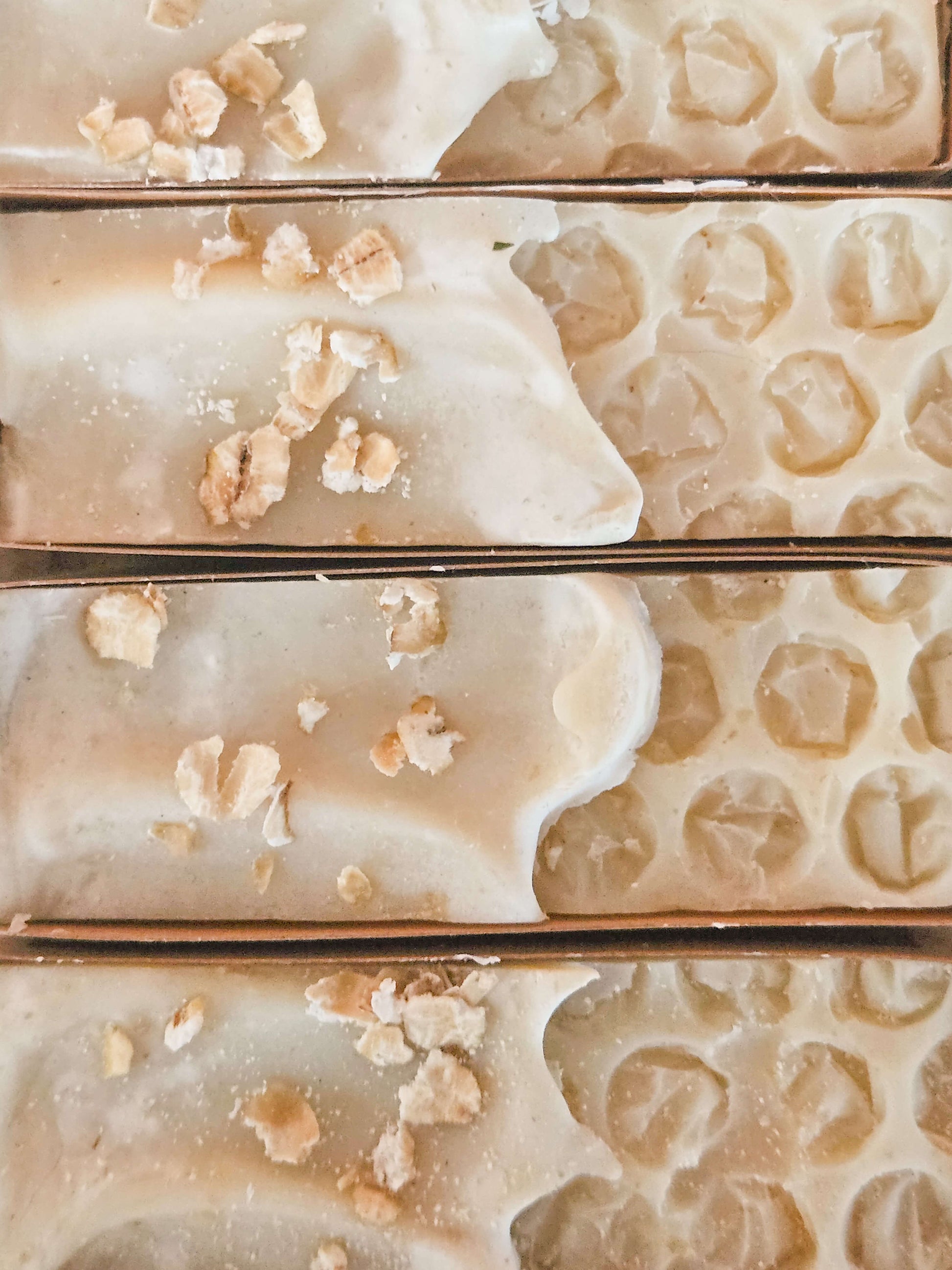 nude unscented uncoloured soap from above with oats scattered on top